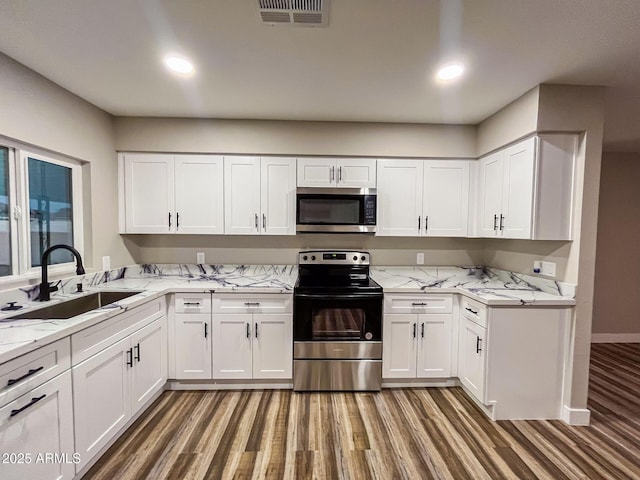 kitchen featuring stainless steel appliances, white cabinetry, and sink