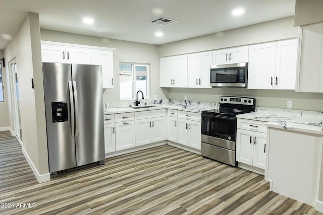 kitchen featuring light stone counters, sink, white cabinets, and appliances with stainless steel finishes