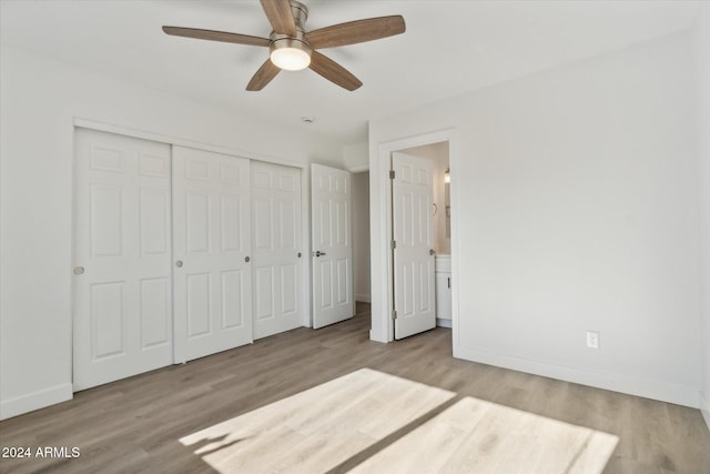 unfurnished bedroom with connected bathroom, ceiling fan, a closet, and light wood-type flooring