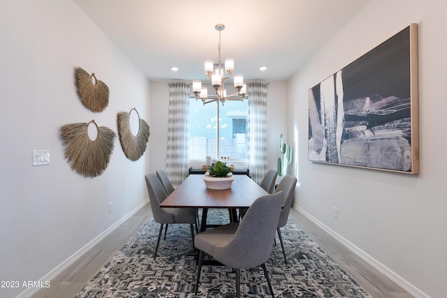 dining area with wood-type flooring and a chandelier