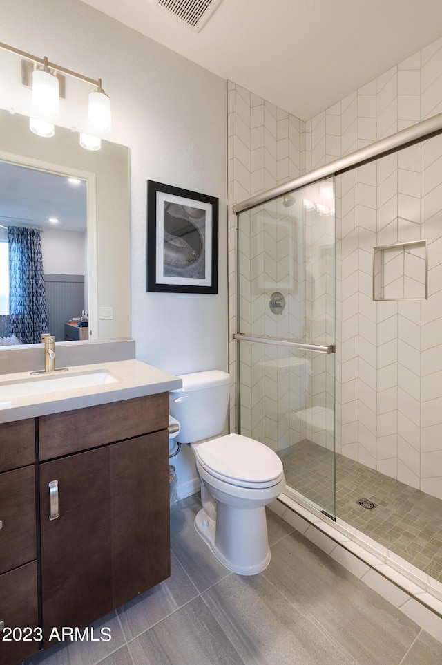 bathroom featuring vanity, toilet, an enclosed shower, and tile patterned flooring