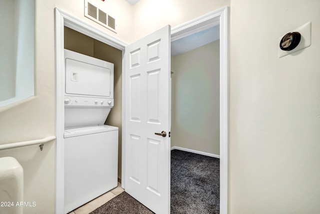 washroom featuring light carpet and stacked washing maching and dryer