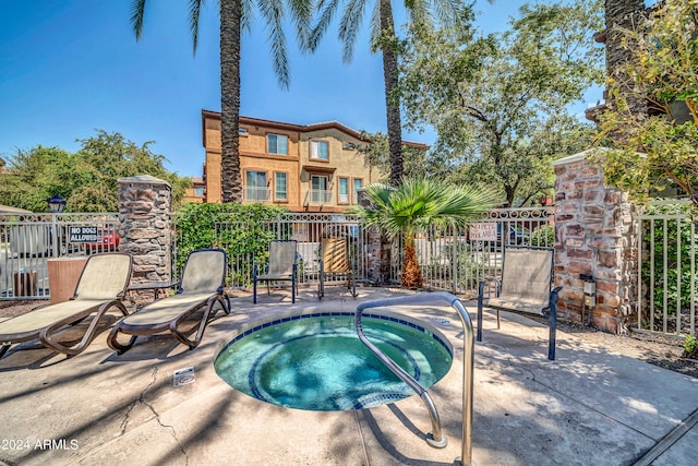 view of swimming pool featuring a hot tub and a patio area