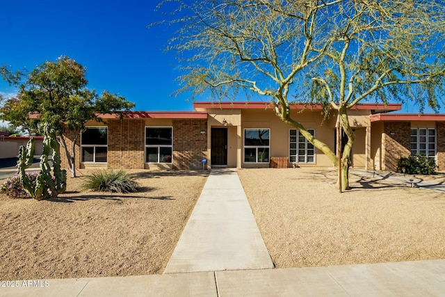 single story home with brick siding and stucco siding