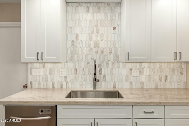 kitchen featuring white cabinets, backsplash, a sink, light stone countertops, and stainless steel dishwasher