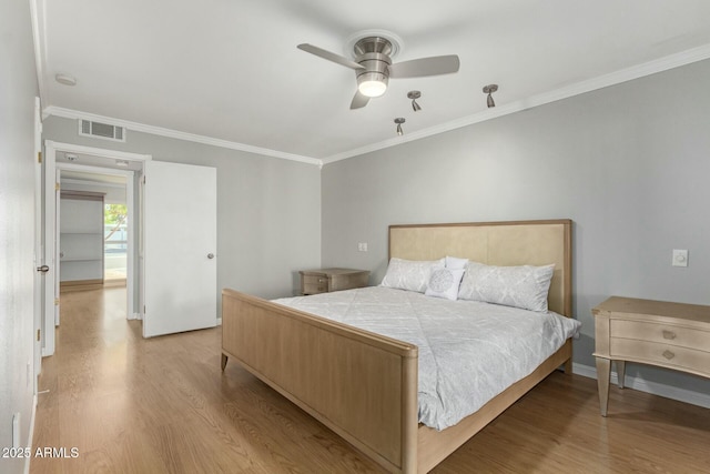 bedroom featuring light wood finished floors, ceiling fan, visible vents, and crown molding