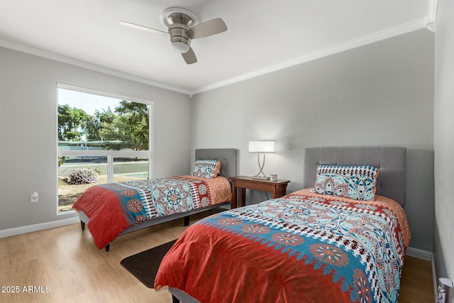 bedroom featuring ceiling fan, crown molding, baseboards, and wood finished floors