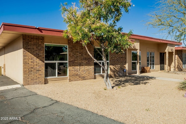 rear view of property with brick siding