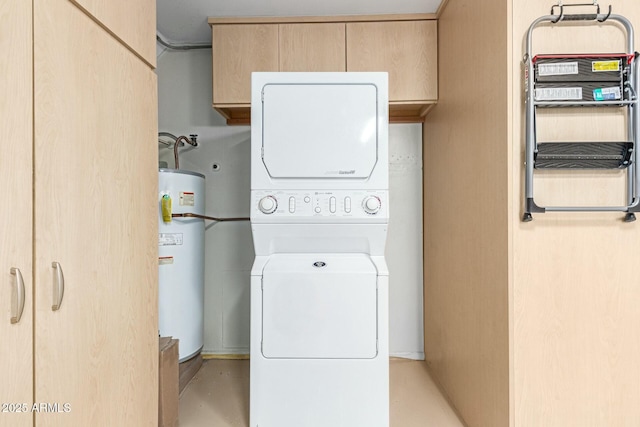 clothes washing area with stacked washer / drying machine, gas water heater, and cabinet space