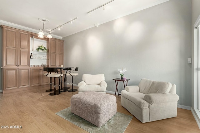 living area with light wood finished floors, baseboards, and crown molding