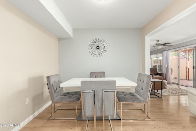 dining room featuring light wood-style flooring, baseboards, and ceiling fan