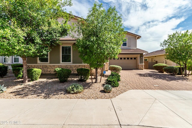 14727 W Pasadena Ave, Litchfield Park, AZ 85340 - view of property hidden behind natural elements with stone siding, decorative driveway, and an attached garage