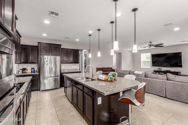 14727 W Pasadena Ave, Litchfield Park, AZ 85340 - kitchen featuring freestanding refrigerator, a sink, open floor plan, light stone counters, and recessed lighting