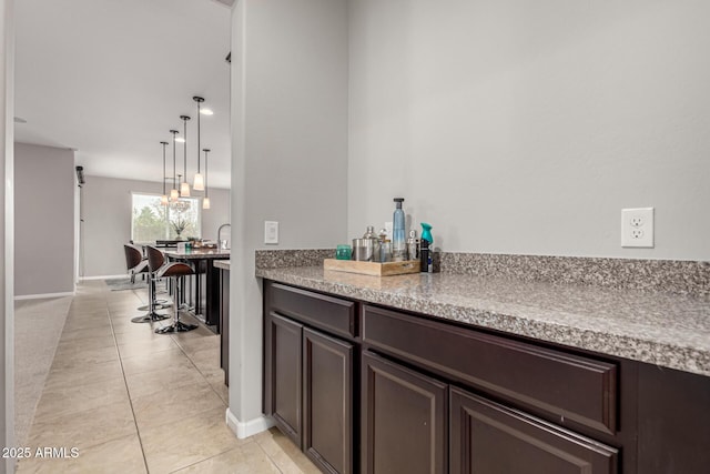 14727 W Pasadena Ave, Litchfield Park, AZ 85340 - bar featuring light tile patterned floors, baseboards, and hanging light fixtures