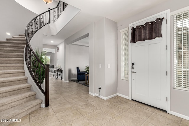 14727 W Pasadena Ave, Litchfield Park, AZ 85340 - entryway featuring light tile patterned floors, stairway, and baseboards
