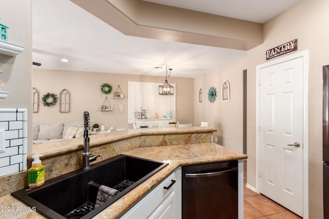 kitchen featuring sink, pendant lighting, light tile patterned floors, dishwasher, and white cabinetry