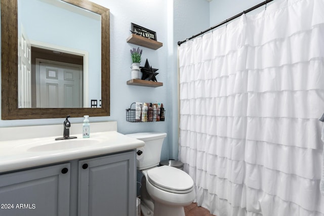 bathroom featuring a shower with curtain, vanity, and toilet