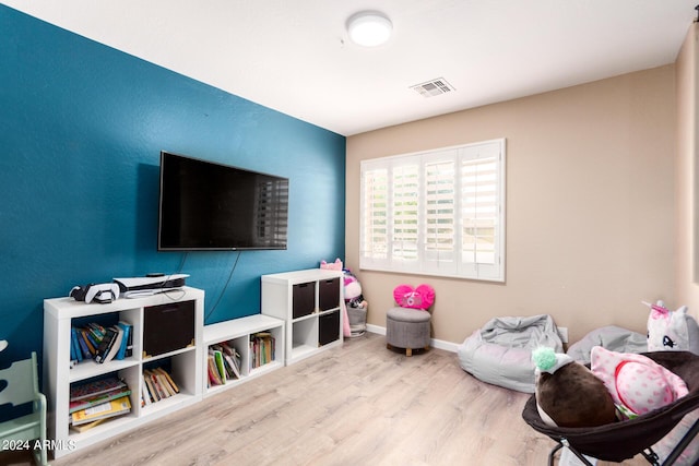 game room with light hardwood / wood-style flooring