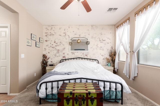 carpeted bedroom featuring multiple windows and ceiling fan