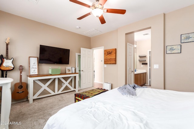 bedroom featuring light carpet, a closet, ensuite bath, and ceiling fan