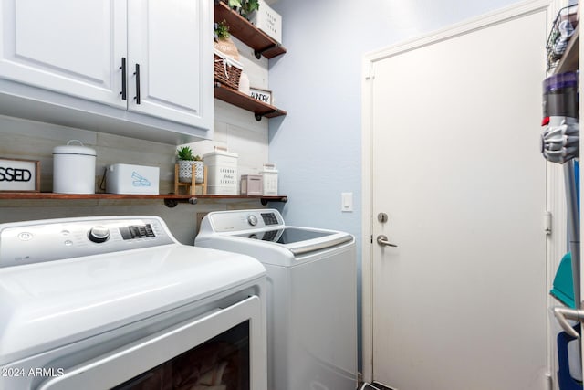 washroom featuring cabinets and separate washer and dryer