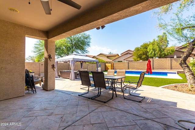 view of patio / terrace with a gazebo, a fenced in pool, and ceiling fan