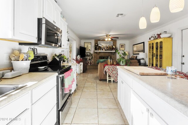 kitchen with pendant lighting, white cabinets, ceiling fan, ornamental molding, and appliances with stainless steel finishes