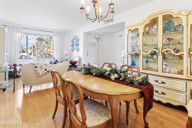 dining space featuring light hardwood / wood-style flooring and a chandelier