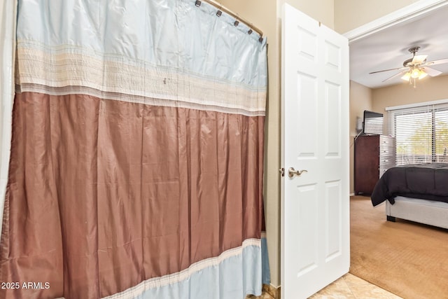 bathroom with curtained shower, tile patterned flooring, and a ceiling fan