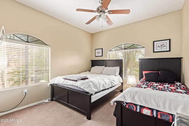 bedroom with carpet floors, multiple windows, ceiling fan, and baseboards