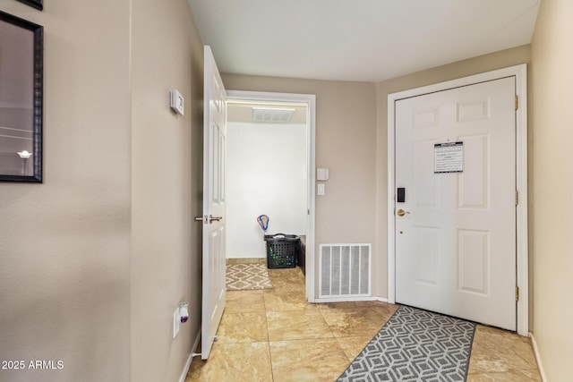 foyer entrance featuring baseboards and visible vents