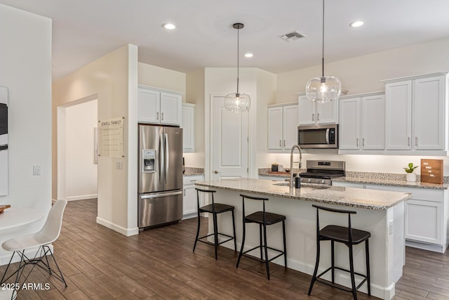 1951 W Plum Rd, Phoenix, AZ 85085 - kitchen with stainless steel appliances, a kitchen breakfast bar, dark wood finished floors, white cabinets, and a kitchen island with sink