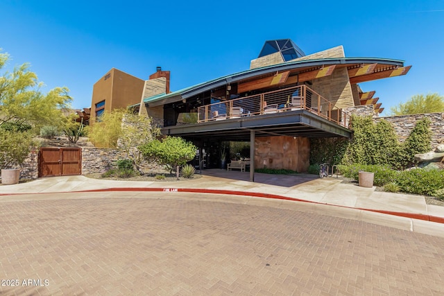 1951 W Plum Rd, Phoenix, AZ 85085 - view of front of house featuring a balcony, a gate, a chimney, and stone siding