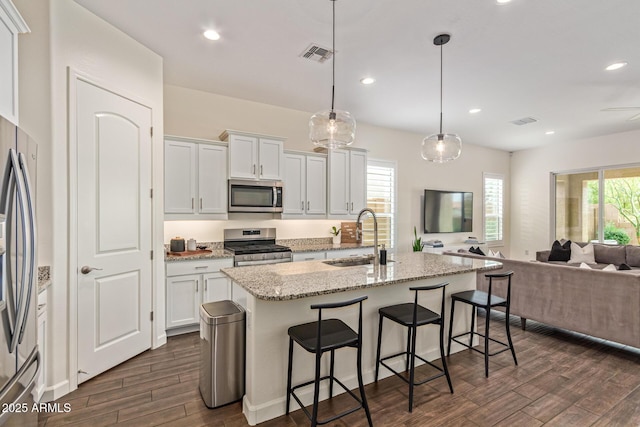 1951 W Plum Rd, Phoenix, AZ 85085 - kitchen featuring stainless steel appliances, a sink, dark wood-style flooring, open floor plan, and a center island with sink
