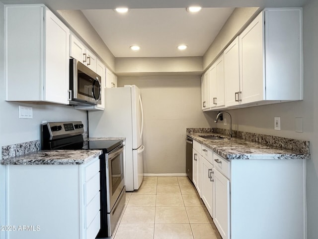 3840 N 43rd Ave Unit 34, Phoenix, AZ 85031 - kitchen featuring stainless steel appliances, a sink, white cabinets, light tile patterned floors, and recessed lighting