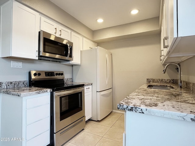 3840 N 43rd Ave Unit 34, Phoenix, AZ 85031 - kitchen featuring stainless steel appliances, a sink, white cabinets, light tile patterned floors, and recessed lighting
