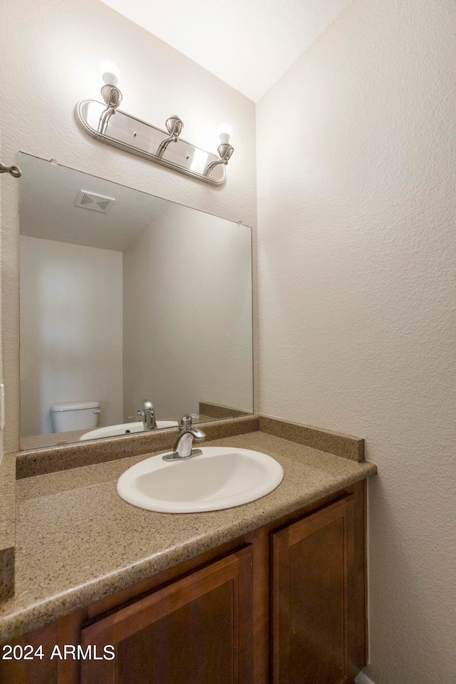 bathroom featuring vanity and toilet