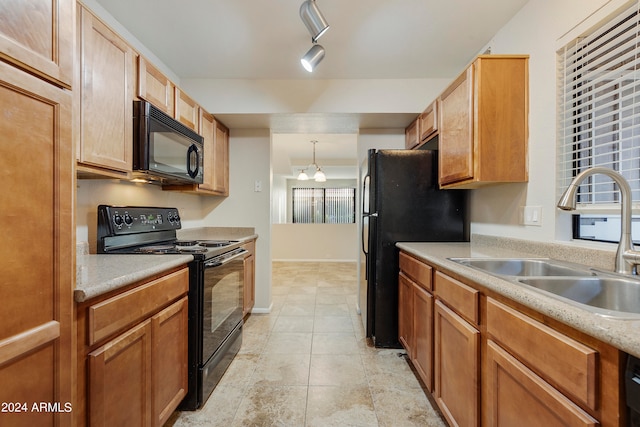 kitchen featuring pendant lighting, black appliances, light tile patterned floors, and sink