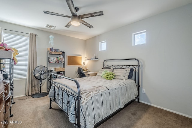 bedroom featuring ceiling fan, multiple windows, and dark colored carpet