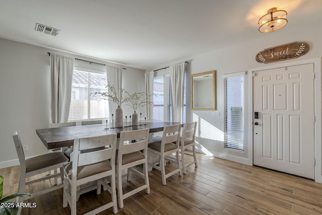 dining space with wood-type flooring