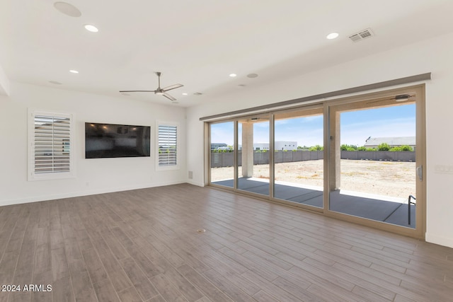 unfurnished living room featuring baseboards, visible vents, wood finished floors, and recessed lighting