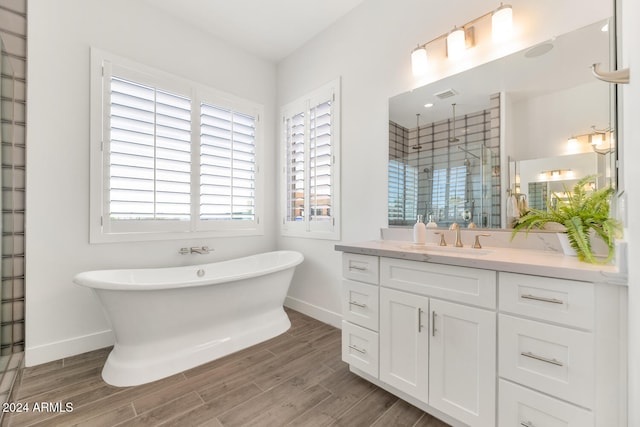 full bathroom with a stall shower, visible vents, baseboards, wood tiled floor, and vanity