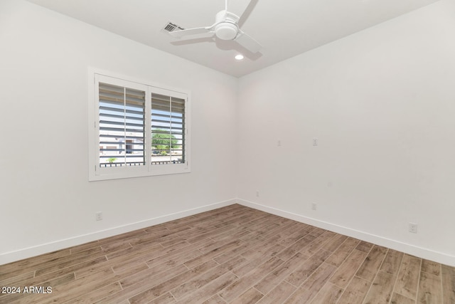 empty room with light wood-style flooring, visible vents, ceiling fan, and baseboards