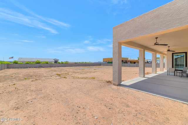 view of yard featuring ceiling fan, a patio, and fence