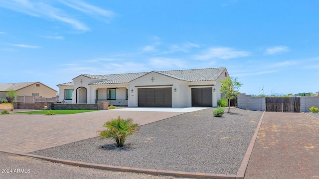 view of front facade featuring a garage, decorative driveway, and fence