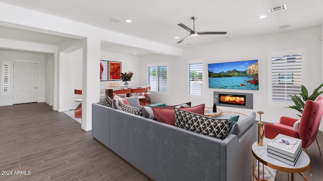 living area with recessed lighting, visible vents, a glass covered fireplace, ceiling fan, and wood finished floors