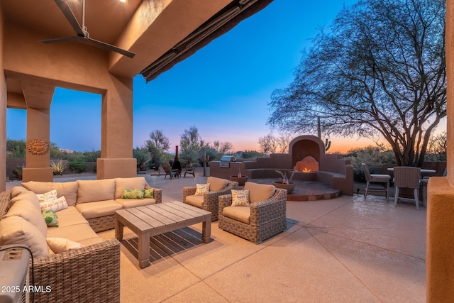 28768 N 95th Way, Scottsdale, AZ 85262 - patio terrace at dusk featuring a patio area, an outdoor living space with a fireplace, and a ceiling fan