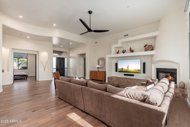 28768 N 95th Way, Scottsdale, AZ 85262 - living area featuring a ceiling fan, light wood-style floors, a warm lit fireplace, and recessed lighting