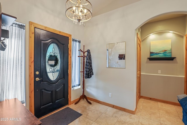 foyer with an inviting chandelier, baseboards, and light tile patterned floors