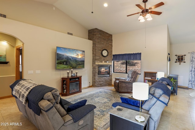 living area with ceiling fan, a fireplace, arched walkways, and light tile patterned flooring